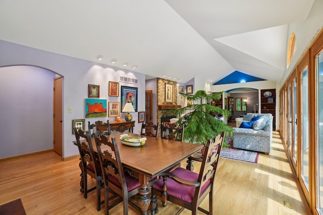 3377 Timberwood Ln, Ann Arbor, MI 48103 - dining space featuring light wood finished floors, arched walkways, vaulted ceiling, healthy amount of natural light, and baseboards