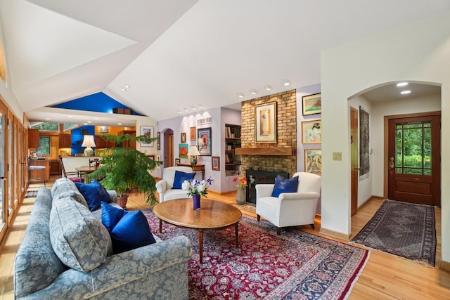 3377 Timberwood Ln, Ann Arbor, MI 48103 - living room with arched walkways, wood finished floors, a brick fireplace, recessed lighting, and vaulted ceiling