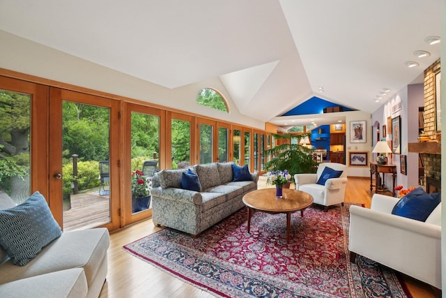 3377 Timberwood Ln, Ann Arbor, MI 48103 - living area with vaulted ceiling, wood finished floors, and a brick fireplace