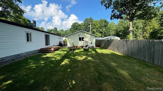 3840 Beech St, Burtchville, MI 48059 - fenced backyard featuring a wooden deck and an outbuilding