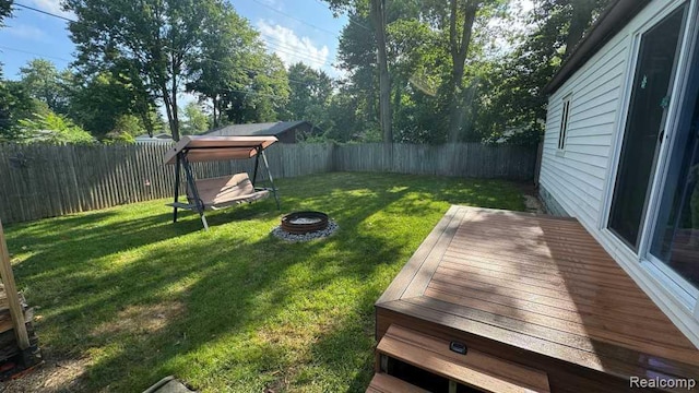 3840 Beech St, Burtchville, MI 48059 - fenced backyard featuring a fire pit and a deck