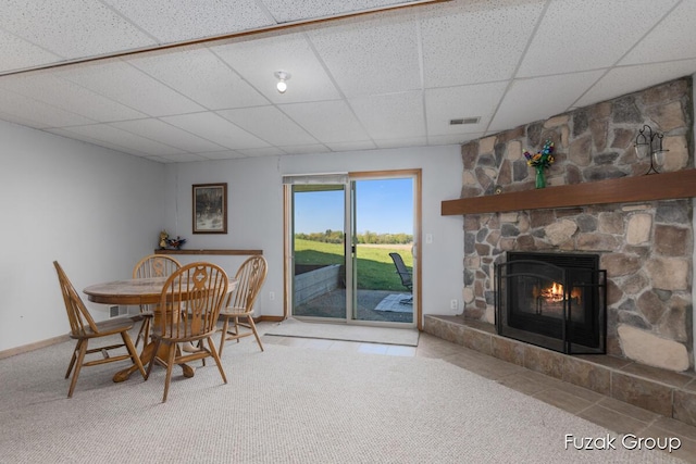 3882 40th St, Hamilton, MI 49419 - carpeted dining room with a paneled ceiling, a stone fireplace, baseboards, and tile patterned floors
