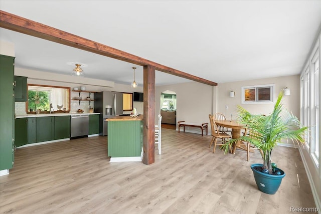 7569 S Durand Rd, Durand, MI 48429 - kitchen with green cabinets, appliances with stainless steel finishes, arched walkways, light countertops, and light wood-style floors