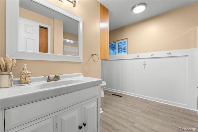 7569 S Durand Rd, Durand, MI 48429 - bathroom with vanity, toilet, wainscoting, and wood finished floors