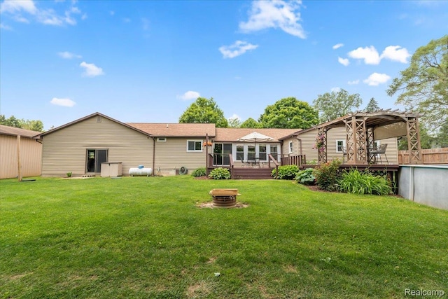 7569 S Durand Rd, Durand, MI 48429 - rear view of house with an outdoor fire pit, a deck, and a yard