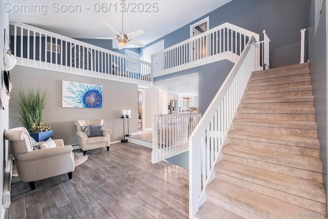 16039 Knobhill Dr, Argentine, MI 48451 - staircase with a high ceiling, wood finished floors, ceiling fan, a baseboard radiator, and baseboards