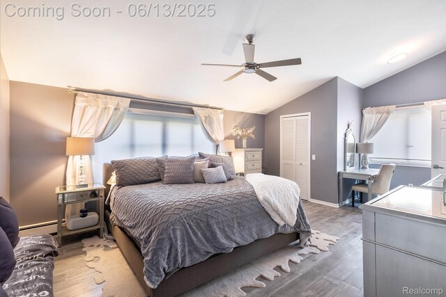 16039 Knobhill Dr, Argentine, MI 48451 - bedroom featuring vaulted ceiling, a closet, wood finished floors, baseboard heating, and a ceiling fan