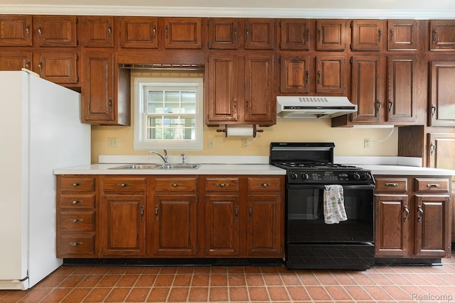 1111 W Park St, Lapeer, MI 48446 - kitchen with range hood, black gas range oven, freestanding refrigerator, and light countertops