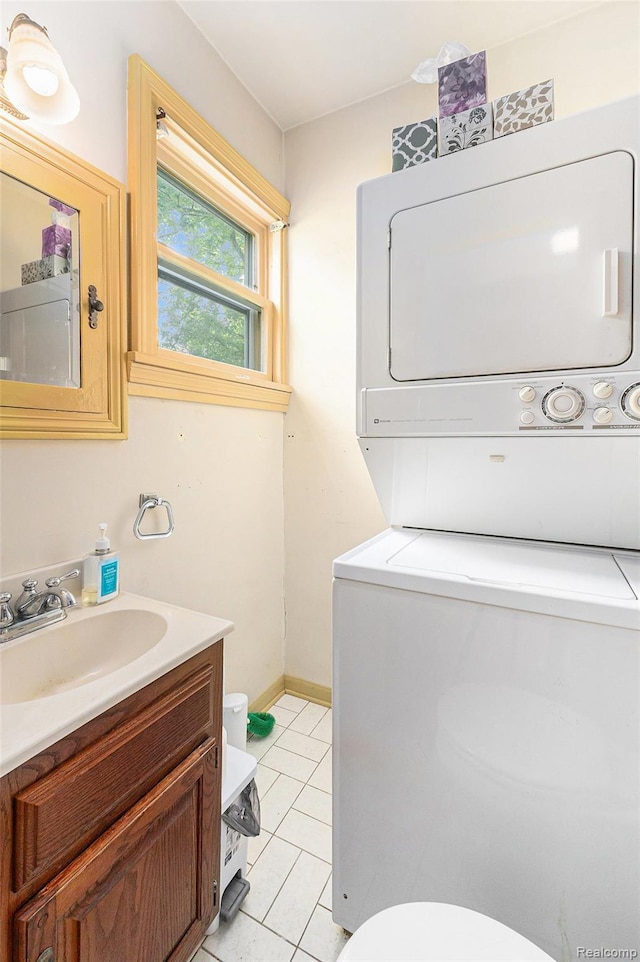 1111 W Park St, Lapeer, MI 48446 - half bathroom featuring stacked washing machine and dryer, toilet, vanity, and tile patterned floors