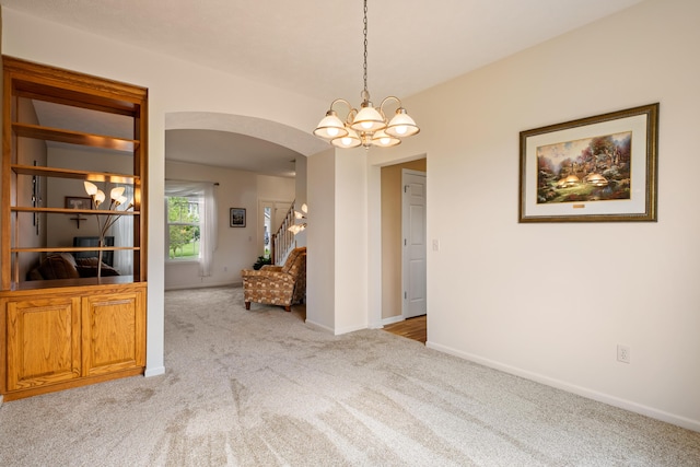 1754 Hightree Dr SW, Byron Center, MI 49315 - carpeted empty room with arched walkways, a chandelier, and baseboards
