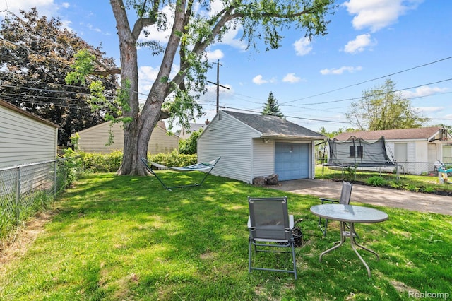 33989 Richard St, Canton, MI 48184 - view of yard featuring an outdoor structure, a trampoline, a detached garage, and driveway