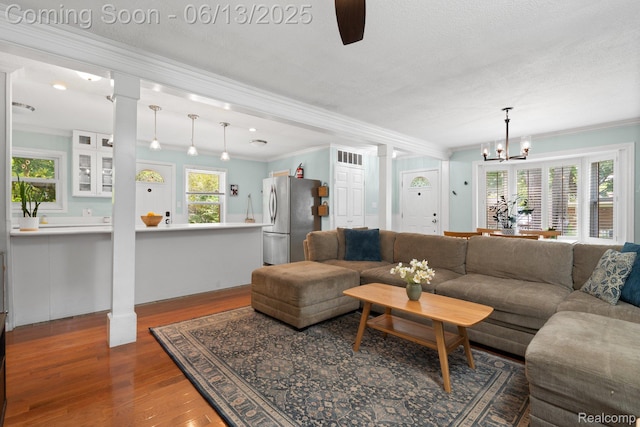 3341 Creek Dr, Ann Arbor, MI 48108 - living room with ornamental molding, wood finished floors, a ceiling fan, and a chandelier