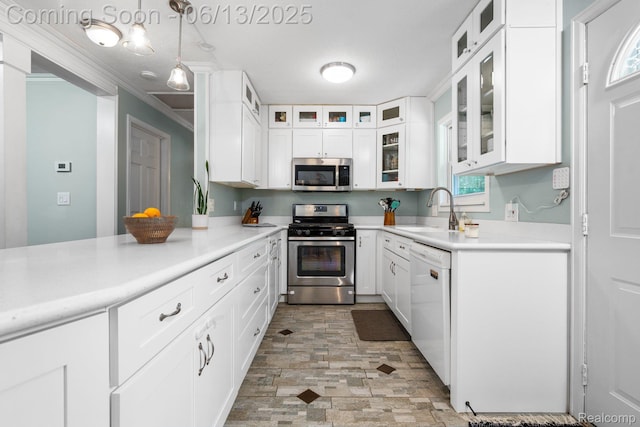 3341 Creek Dr, Ann Arbor, MI 48108 - kitchen with appliances with stainless steel finishes, light countertops, white cabinetry, pendant lighting, and ornamental molding