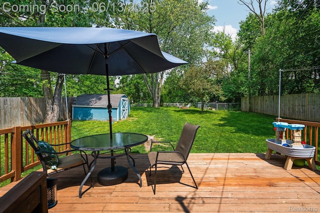 3341 Creek Dr, Ann Arbor, MI 48108 - deck with a fenced backyard, outdoor dining space, a shed, and view of wooded area