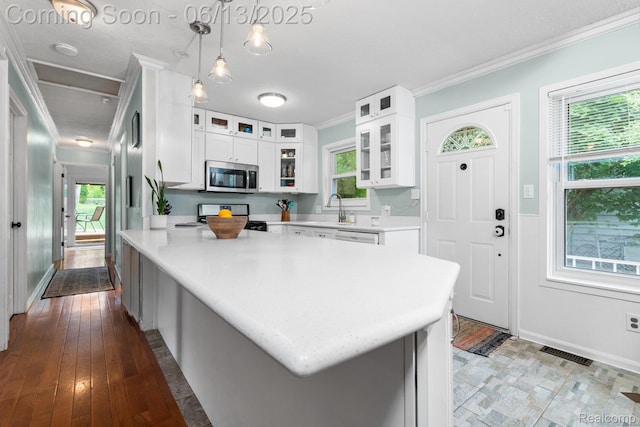 3341 Creek Dr, Ann Arbor, MI 48108 - kitchen featuring stainless steel microwave, stove, crown molding, light countertops, and white cabinets