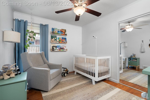 3341 Creek Dr, Ann Arbor, MI 48108 - bedroom featuring wood finished floors, a crib, ornamental molding, and a ceiling fan