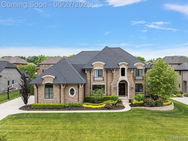 3610 Piccadilly Dr, Rochester Hills, MI 48309 - french country style house featuring brick siding, a front yard, and roof with shingles