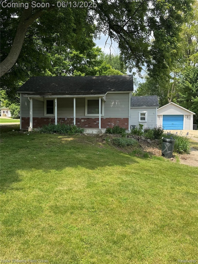 525 E Saint Clair St, Almont, MI 48003 - ranch-style home with brick siding, a front lawn, covered porch, a detached garage, and an outdoor structure
