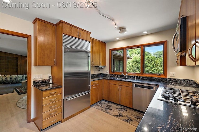2732 Lone Pine Rd, West Bloomfield, MI 48323 - kitchen with stainless steel appliances, brown cabinets, light wood-style floors, dark stone countertops, and recessed lighting