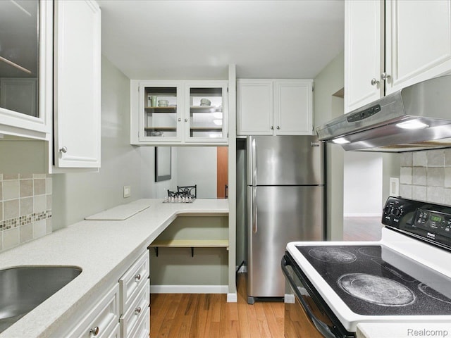 810 Holland Ave Unit 5, Port Huron, MI 48060 - kitchen featuring range with electric cooktop, freestanding refrigerator, extractor fan, decorative backsplash, and white cabinetry