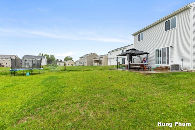 5764 Kiverton Ridge Dr SE, Grand Rapids, MI 49508 - view of grassy yard featuring a gazebo, a trampoline, a residential view, and central AC unit