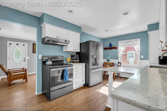 24121 Kraft Pl, Brownstown, MI 48174 - kitchen featuring appliances with stainless steel finishes, under cabinet range hood, white cabinetry, light wood-style floors, and light stone countertops