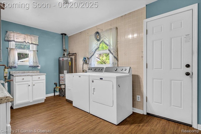24121 Kraft Pl, Brownstown, MI 48174 - washroom with separate washer and dryer, gas water heater, wood finished floors, tile walls, and cabinet space