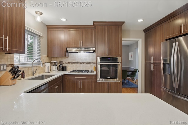 6821 Tamerlane Dr, West Bloomfield, MI 48322 - kitchen featuring appliances with stainless steel finishes, under cabinet range hood, light countertops, backsplash, and recessed lighting