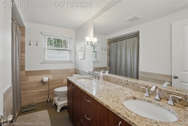 6821 Tamerlane Dr, West Bloomfield, MI 48322 - bathroom featuring tile walls, tile patterned flooring, double vanity, a wainscoted wall, and curtained shower