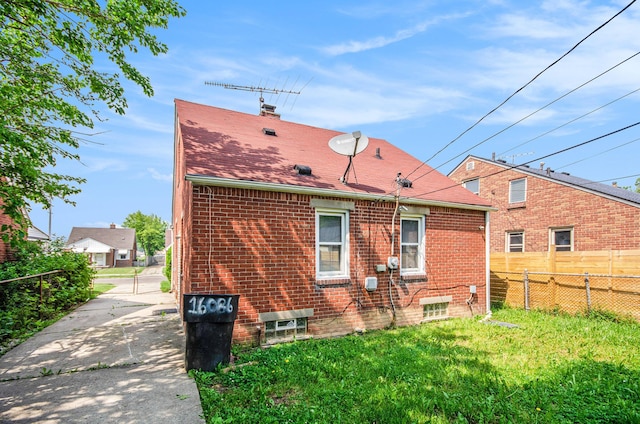 16086 Carlisle St, Detroit, MI 48205 - back of property featuring a chimney, brick siding, and roof with shingles