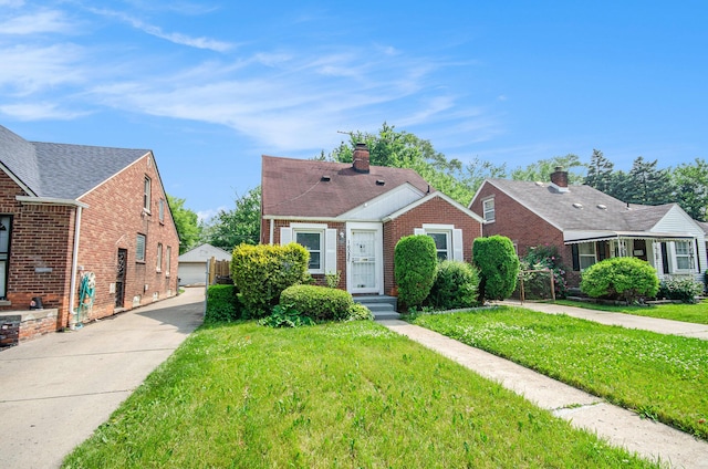 16086 Carlisle St, Detroit, MI 48205 - bungalow-style home with brick siding, a front yard, an outdoor structure, and a garage