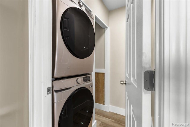 16558 Indiana St, Detroit, MI 48221 - laundry area featuring stacked washer and clothes dryer, light wood finished floors, and baseboards