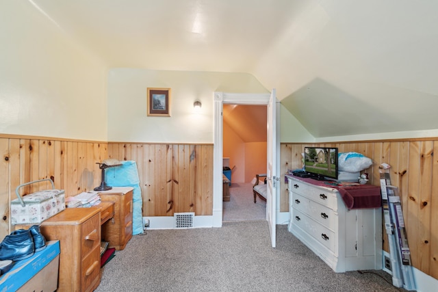 1704 Pringle Ave, Jackson, MI 49203 - bedroom featuring vaulted ceiling, carpet, a wainscoted wall, and wooden walls