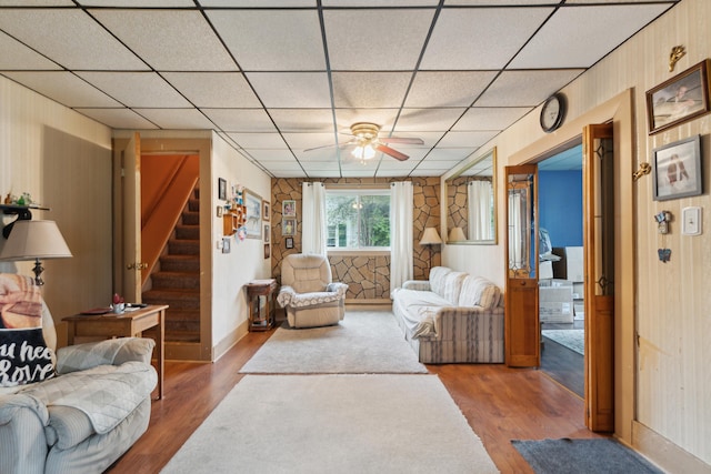 1704 Pringle Ave, Jackson, MI 49203 - living area featuring wood finished floors, stairs, a ceiling fan, a paneled ceiling, and baseboards