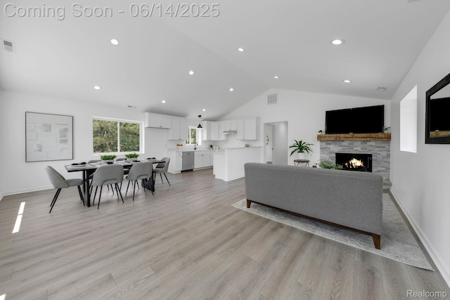 2694 Vendome Ave, Rochester Hills, MI 48309 - living area featuring a warm lit fireplace, light wood-style floors, high vaulted ceiling, and recessed lighting