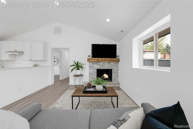 2694 Vendome Ave, Rochester Hills, MI 48309 - living area featuring light wood-style floors, lofted ceiling, and a warm lit fireplace