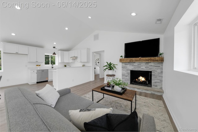2694 Vendome Ave, Rochester Hills, MI 48309 - living room with a stone fireplace, light wood-style flooring, recessed lighting, and high vaulted ceiling