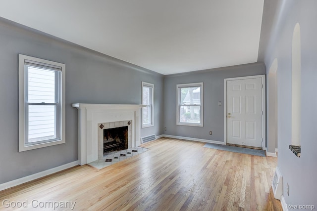 263 E Woodland St, Ferndale, MI 48220 - unfurnished living room featuring wood finished floors, a fireplace, and arched walkways