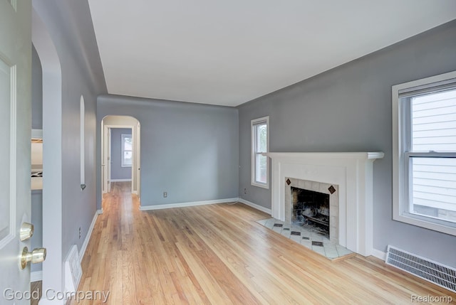 263 E Woodland St, Ferndale, MI 48220 - unfurnished living room featuring arched walkways, wood finished floors, plenty of natural light, and radiator