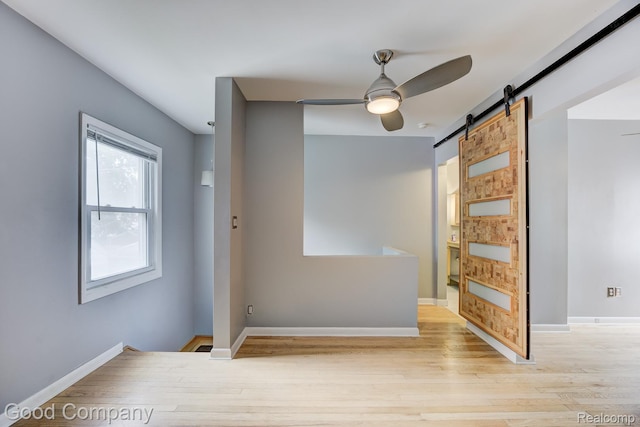 263 E Woodland St, Ferndale, MI 48220 - empty room featuring a barn door, a ceiling fan, and light wood-style floors