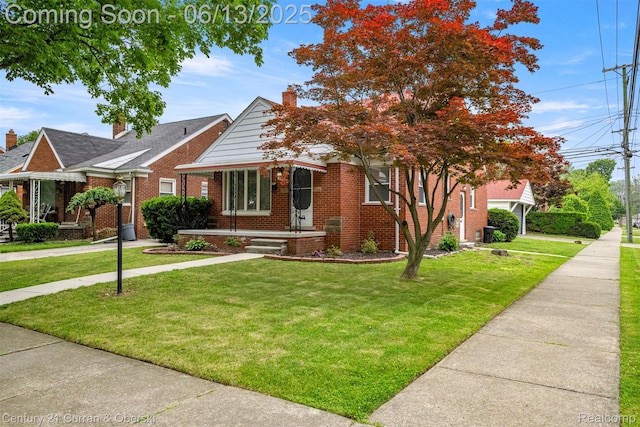 8904 Becker Ave, Allen Park, MI 48101 - bungalow with brick siding, a front yard, and a chimney