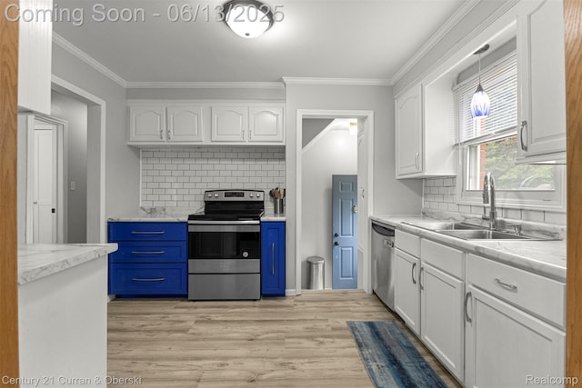 8904 Becker Ave, Allen Park, MI 48101 - kitchen featuring stainless steel appliances, white cabinets, light wood-style flooring, blue cabinets, and ornamental molding