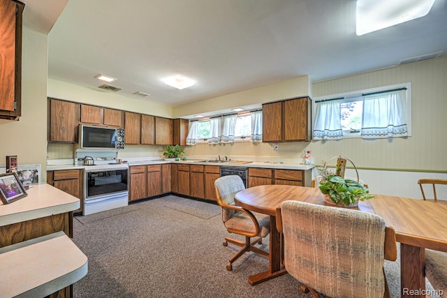 23880 Glencreek Dr, Farmington Hills, MI 48336 - kitchen with white range with electric cooktop, black microwave, brown cabinets, and light countertops