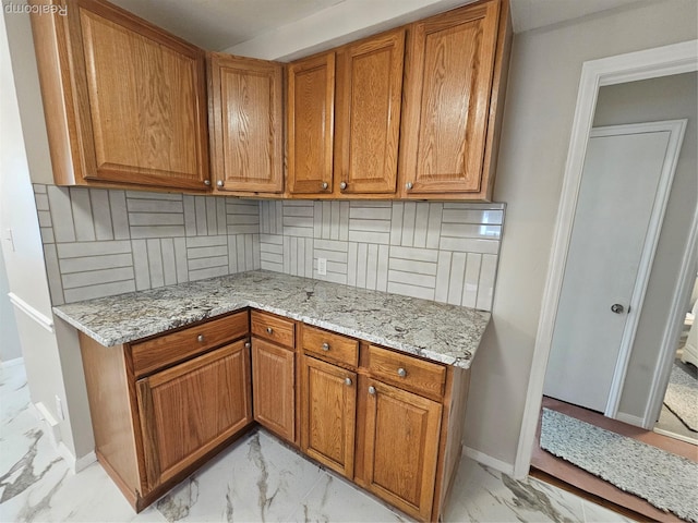 9311 Dixie, Redford, MI 48239 - kitchen featuring light marble finish flooring, brown cabinets, decorative backsplash, and light stone counters