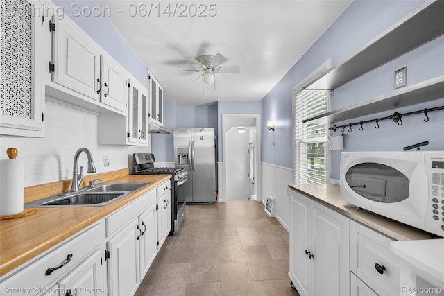 3156 Edgewood St, Dearborn, MI 48124 - kitchen featuring appliances with stainless steel finishes, white cabinetry, a ceiling fan, light countertops, and a wainscoted wall