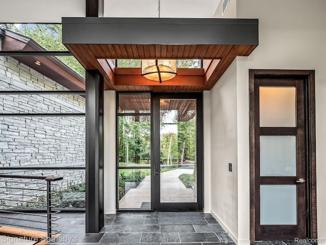 6956 Cooley Lake Rd, White Lake, MI 48383 - doorway featuring baseboards, dark stone finish flooring, and a skylight