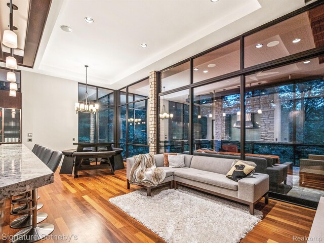 6956 Cooley Lake Rd, White Lake, MI 48383 - living area featuring floor to ceiling windows, wood finished floors, a chandelier, a raised ceiling, and recessed lighting