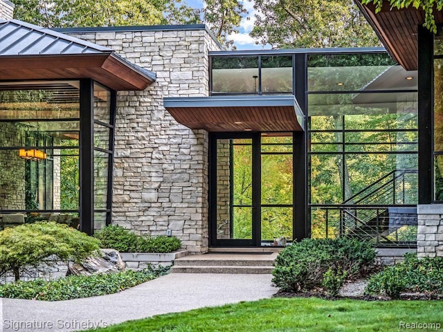 6956 Cooley Lake Rd, White Lake, MI 48383 - doorway to property featuring stone siding and a standing seam roof