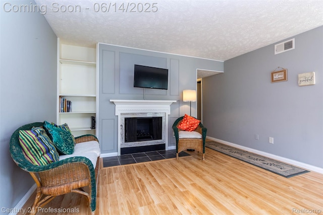 2024 Hamilton Rd Unit 6, Okemos, MI 48864 - living area with wood finished floors, a textured ceiling, a fireplace, and baseboards