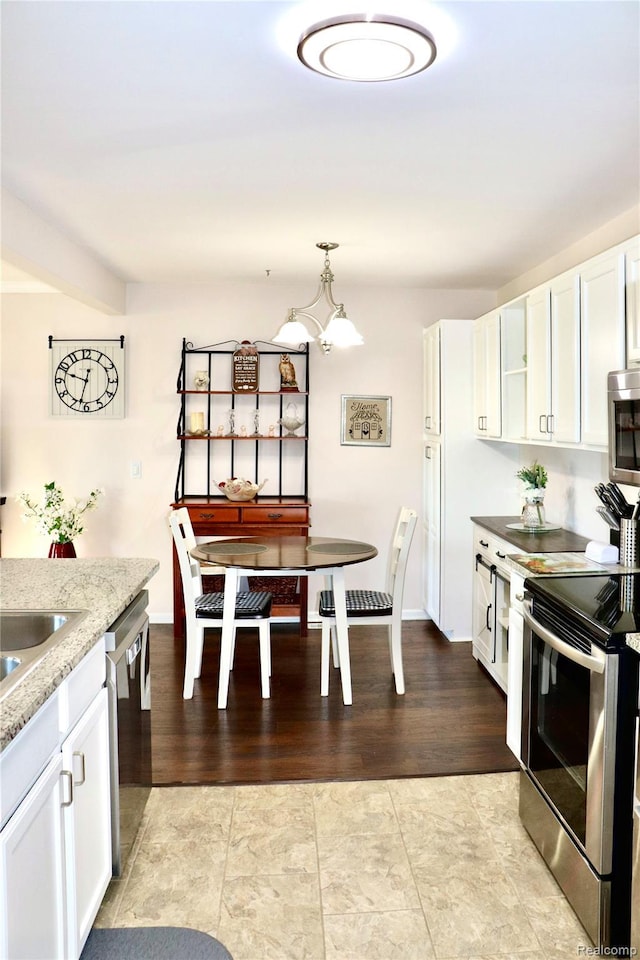 9418 Parkwood Dr N, Davison, MI 48423 - kitchen with appliances with stainless steel finishes, white cabinetry, a chandelier, and light stone counters